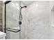 Bright bathroom shower featuring marble-look tile, a black shower head, and a sleek glass enclosure with black hardware at 7030 19Th N Way, St Petersburg, FL 33702