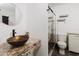 Bathroom with granite countertop and vessel sink next to glass-enclosed shower at 7213 Trinity Pl, Tampa, FL 33610