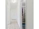 Well-lit hallway leading to a bathroom with a tiled shower, offering convenience and style at 7213 Trinity Pl, Tampa, FL 33610