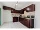 A well-lit kitchen with dark cabinets and stone countertops at 7213 Trinity Pl, Tampa, FL 33610