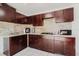 A fully equipped kitchen featuring granite countertops, dark wood cabinetry and stainless steel appliances at 7213 Trinity Pl, Tampa, FL 33610