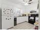 Bright kitchen featuring white cabinets, updated appliances, granite countertops, and a ceiling fan at 7213 Trinity Pl, Tampa, FL 33610
