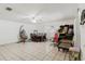 Open-concept living room and dining room with tile flooring, ceiling fan and ample natural light at 7213 Trinity Pl, Tampa, FL 33610