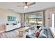 Sun-filled living room showcasing modern furnishings, a ceiling fan, and large windows with a view of the outdoors at 930 Dumont Dr, Dunedin, FL 34698