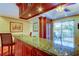 Beautiful kitchen bar with granite countertops, cherry wood cabinets, and sliding glass door to outdoor patio at 936 Pinellas Bayway S # T-7, Tierra Verde, FL 33715
