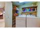Laundry room features newer washer, dryer, and storage shelves at 936 Pinellas Bayway S # T-7, Tierra Verde, FL 33715