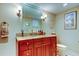 Bathroom featuring a cherry vanity with granite countertop and a decorative mirror above sink at 936 Pinellas Bayway S # T-7, Tierra Verde, FL 33715