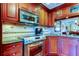 Close up kitchen boasts stainless appliances, granite countertops, and cherry wood cabinets at 936 Pinellas Bayway S # T-7, Tierra Verde, FL 33715