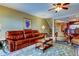 Inviting living room with a comfortable leather sofa, ceiling fan and access to the dining area at 936 Pinellas Bayway S # T-7, Tierra Verde, FL 33715