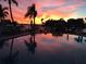 Waterfront pool reflecting a vibrant sunset with palm trees and boat docks at 936 Pinellas Bayway S # T-7, Tierra Verde, FL 33715