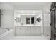 Bright bathroom featuring double vanity, soaking tub, and a glass shower with a modern, clean design at 960 Starkey Rd # 3406, Largo, FL 33771