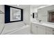 Bright bathroom showcasing a soaking tub with tile surround, vanity with sink, and elegant mirrors at 960 Starkey Rd # 3406, Largo, FL 33771