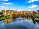 Scenic view of a serene pond with a fountain, surrounded by buildings under a blue sky at 960 Starkey Rd # 3406, Largo, FL 33771