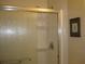 Bathroom featuring sliding glass shower door with metal trim and decorative painting on the wall at 9911 Dahlia N St # 38, Pinellas Park, FL 33782