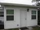 Exterior of home featuring white siding, windows, and a door with a light fixture above at 9911 Dahlia N St # 38, Pinellas Park, FL 33782