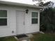 Home exterior showcases bright white siding, windows, a door, and tropical plants nearby at 9911 Dahlia N St # 38, Pinellas Park, FL 33782