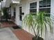 Charming house exterior featuring a brick walkway, textured siding, well-placed landscaping, and white trim at 9911 Dahlia N St # 38, Pinellas Park, FL 33782