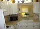Bright kitchen with white cabinets, a window over the sink, and updated appliances at 9911 Dahlia N St # 38, Pinellas Park, FL 33782