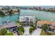 Expansive aerial view of a waterfront home boasting modern architecture, lush landscaping, and a private driveway at 10100 Tarpon Dr, Treasure Island, FL 33706