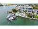 Aerial view of a home with a private boat dock, swimming pool, and beautifully landscaped backyard on the water at 10100 Tarpon Dr, Treasure Island, FL 33706