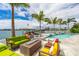 Waterfront backyard featuring a pool, dock, and multiple seating areas perfect for outdoor entertaining at 10100 Tarpon Dr, Treasure Island, FL 33706