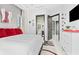 Modern bedroom with a white bedspread, red pillows, and a view to the bathroom at 10100 Tarpon Dr, Treasure Island, FL 33706