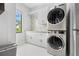 Bright laundry room featuring a modern washer/dryer, ample storage, and a stylish backsplash at 10100 Tarpon Dr, Treasure Island, FL 33706