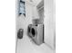 Efficient laundry room with modern appliances, cabinets, and mosaic tile accent at 10100 Tarpon Dr, Treasure Island, FL 33706