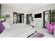 Bright bedroom featuring a white platform bed, sleek dresser, and sliding door access to a balcony at 10100 Tarpon Dr, Treasure Island, FL 33706