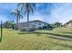 Backyard showcasing a wood deck, lush green lawn, and vibrant palm trees on a sunny day at 1025 Apollo Beach Blvd # 1, Apollo Beach, FL 33572