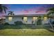 Charming single-story home with lush lawn, palm trees, and a vibrant sunset sky at 1025 Apollo Beach Blvd # 1, Apollo Beach, FL 33572