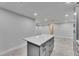 Modern kitchen island with quartz countertop and gray cabinetry against neutral walls at 1025 Apollo Beach Blvd # 1, Apollo Beach, FL 33572