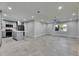 Open-concept living room with tile floors, modern kitchen, and an entrance door at 1025 Apollo Beach Blvd # 1, Apollo Beach, FL 33572