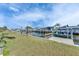 Waterfront view featuring docks, lush green lawn, and vibrant palm trees on a sunny day at 1025 Apollo Beach Blvd # 1, Apollo Beach, FL 33572