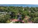 Aerial view of a home with a long driveway and a water view beyond lush, green trees at 1130 Serpentine S Dr, St Petersburg, FL 33705
