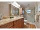 Updated bathroom featuring a tile shower, marble countertops, and wood floors at 1130 Serpentine S Dr, St Petersburg, FL 33705