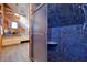 Bathroom with angled wood paneling that features a blue tiled shower with a bench at 1130 Serpentine S Dr, St Petersburg, FL 33705
