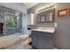 Modern bathroom featuring gray cabinetry, glass shower, and tile backsplash at 1130 Serpentine S Dr, St Petersburg, FL 33705