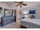 Bright bedroom featuring a ceiling fan, wooden dresser, and comfortable bed at 1130 Serpentine S Dr, St Petersburg, FL 33705
