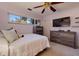 Comfortable bedroom featuring a ceiling fan, wooden dresser, and a window at 1130 Serpentine S Dr, St Petersburg, FL 33705