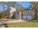 Two story home with a two car garage and a brick driveway surrounded by lush landscaping at 1130 Serpentine S Dr, St Petersburg, FL 33705