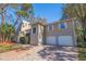 Two story home with a two car garage and a brick driveway surrounded by lush landscaping at 1130 Serpentine S Dr, St Petersburg, FL 33705