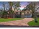 Charming home featuring a brick driveway, lush lawn, and mature trees at 1130 Serpentine S Dr, St Petersburg, FL 33705