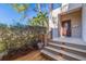 Front porch and door with gray deck and wood railing surrounded by greenery at 1130 Serpentine S Dr, St Petersburg, FL 33705