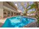 The sparkling pool is surrounded by a brick patio and lush landscaping at 1130 Serpentine S Dr, St Petersburg, FL 33705