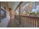 Long covered porch with wooden floors and railing, perfect for outdoor enjoyment at 1130 Serpentine S Dr, St Petersburg, FL 33705