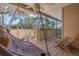Relaxing covered porch featuring a hammock swing, a wooden chair, and a ceiling fan at 1130 Serpentine S Dr, St Petersburg, FL 33705