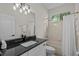 Clean bathroom with a dark countertop, shower-tub combo, and decorative vanity lighting at 11611 Jordans Landing Ct, Riverview, FL 33569