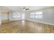 Bright living room with plantation shutters, a ceiling fan, and wood-look floors at 1175 San Carlos Ne Ave, St Petersburg, FL 33702