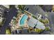 Aerial shot of a community pool and lounge area surrounded by palm trees and parking at 1200 Country Club Dr # 4301, Largo, FL 33771